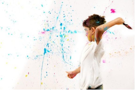woman throwing pain on wall