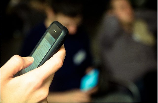 hands typing on mobile phone