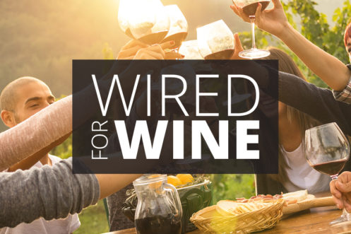 A group of people raising glasses of wine in a toast outdoors with the text "Wired for Wine" overlaid.