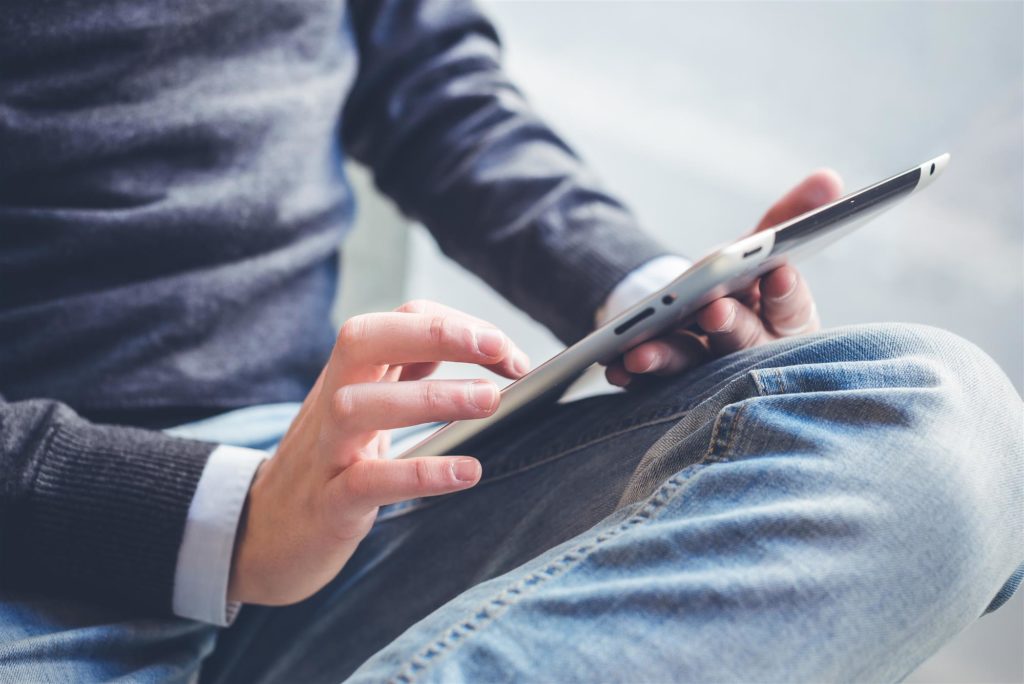 Man's hands using slim tablet device