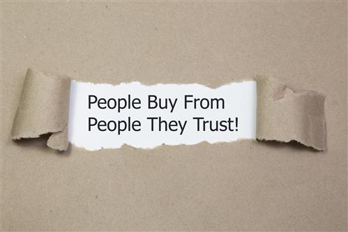 Torn strip of paper reveals quote - People Buy from People They Trust