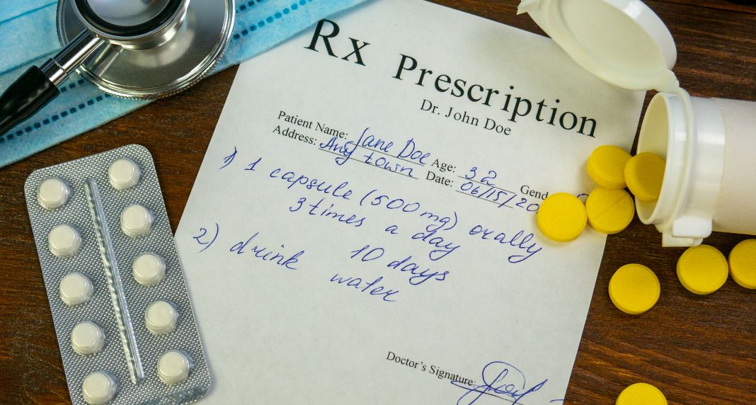 doctors prescription on desk with yellow pills