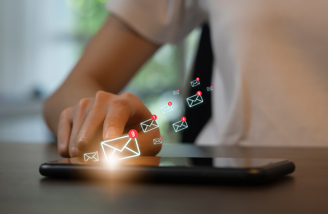 woman touching cell phone and email icons floating off screen